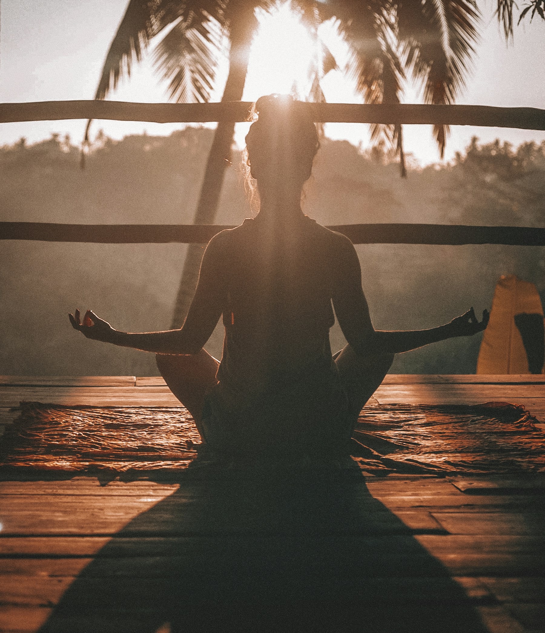 Person sitting mindfully in a sunlit outdoor wellness space